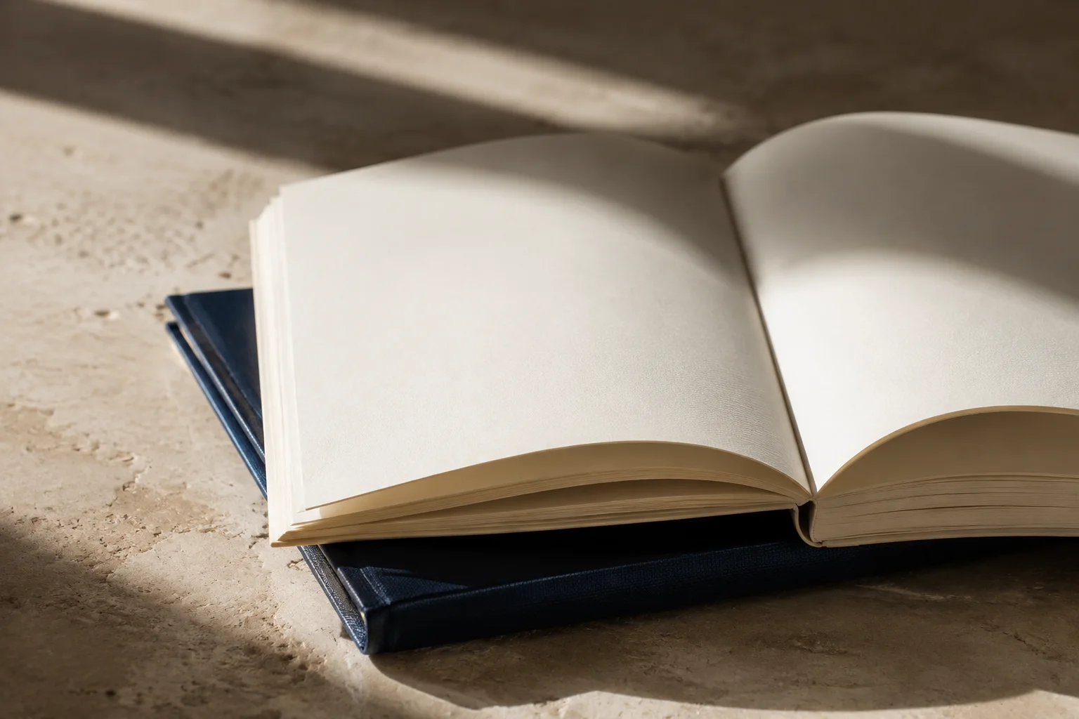 An open book and navy linen cover in warm afternoon light